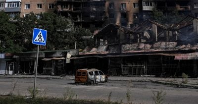 Burned out cars, rubble from flattened buildings strewn along deserted streets